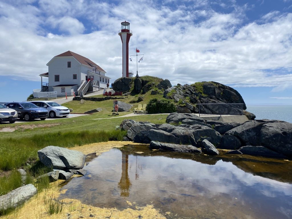 a view and reflection of the cape forchu apple core lighthouse in yarmouth nova scotia